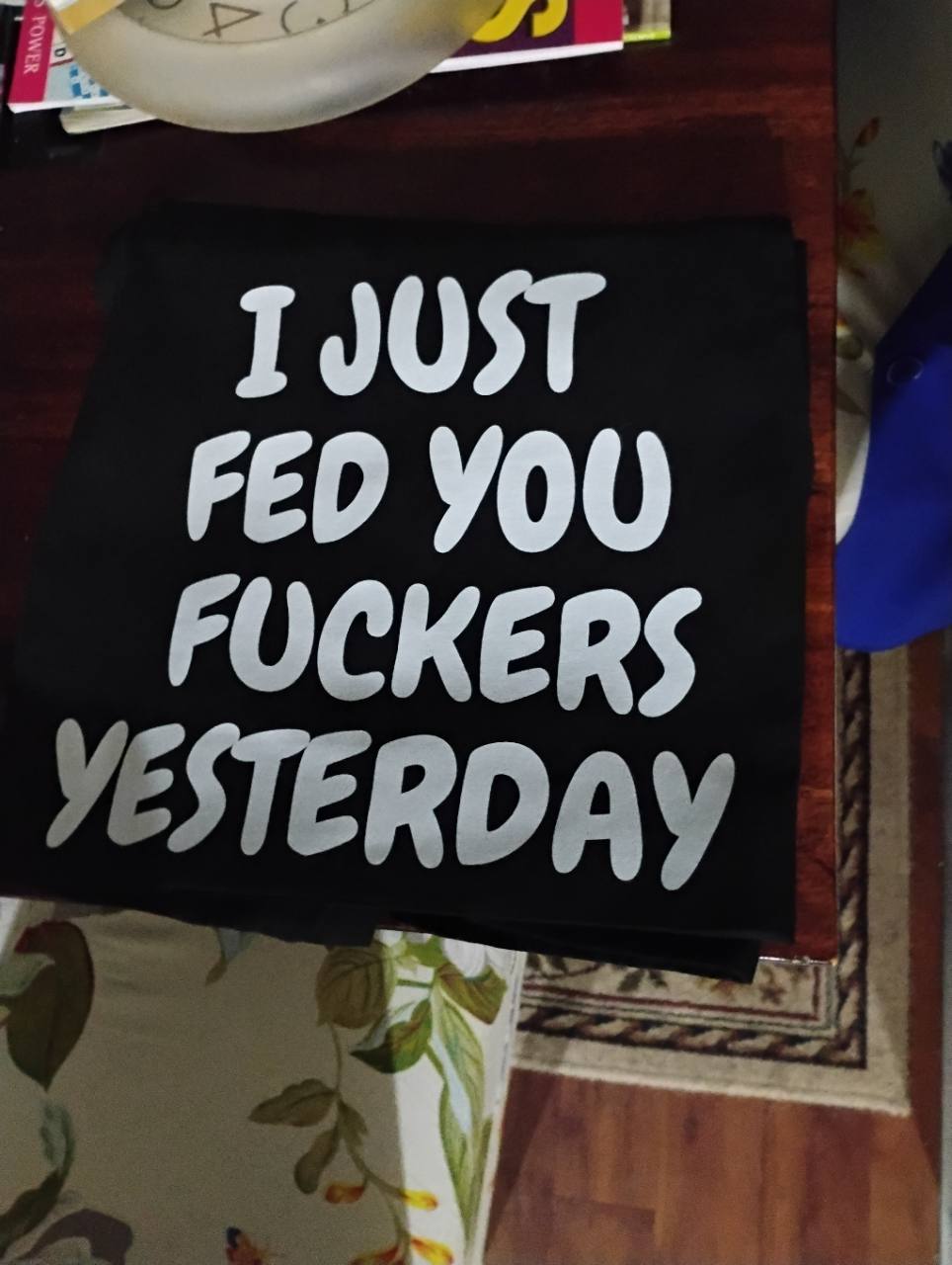 Black garment with large white lettering reading “I just fed you fuckers yesterday”.