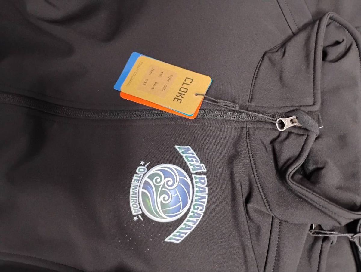 Close-up of the Ngā Rangatahi O Te Wairoa chest print on a charcoal zip jacket.