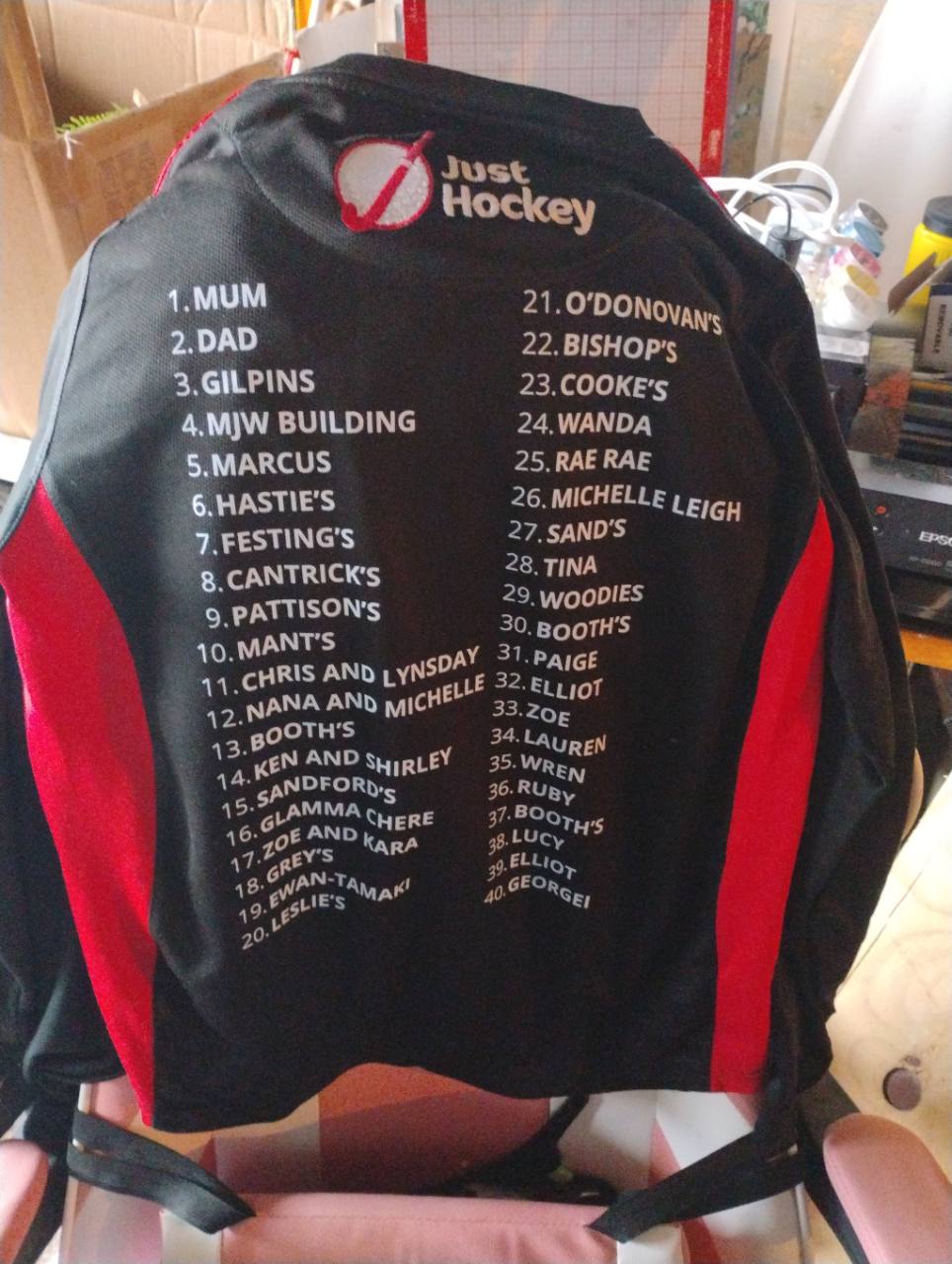 Black and red sports shirt with two columns of numbered names printed in white.