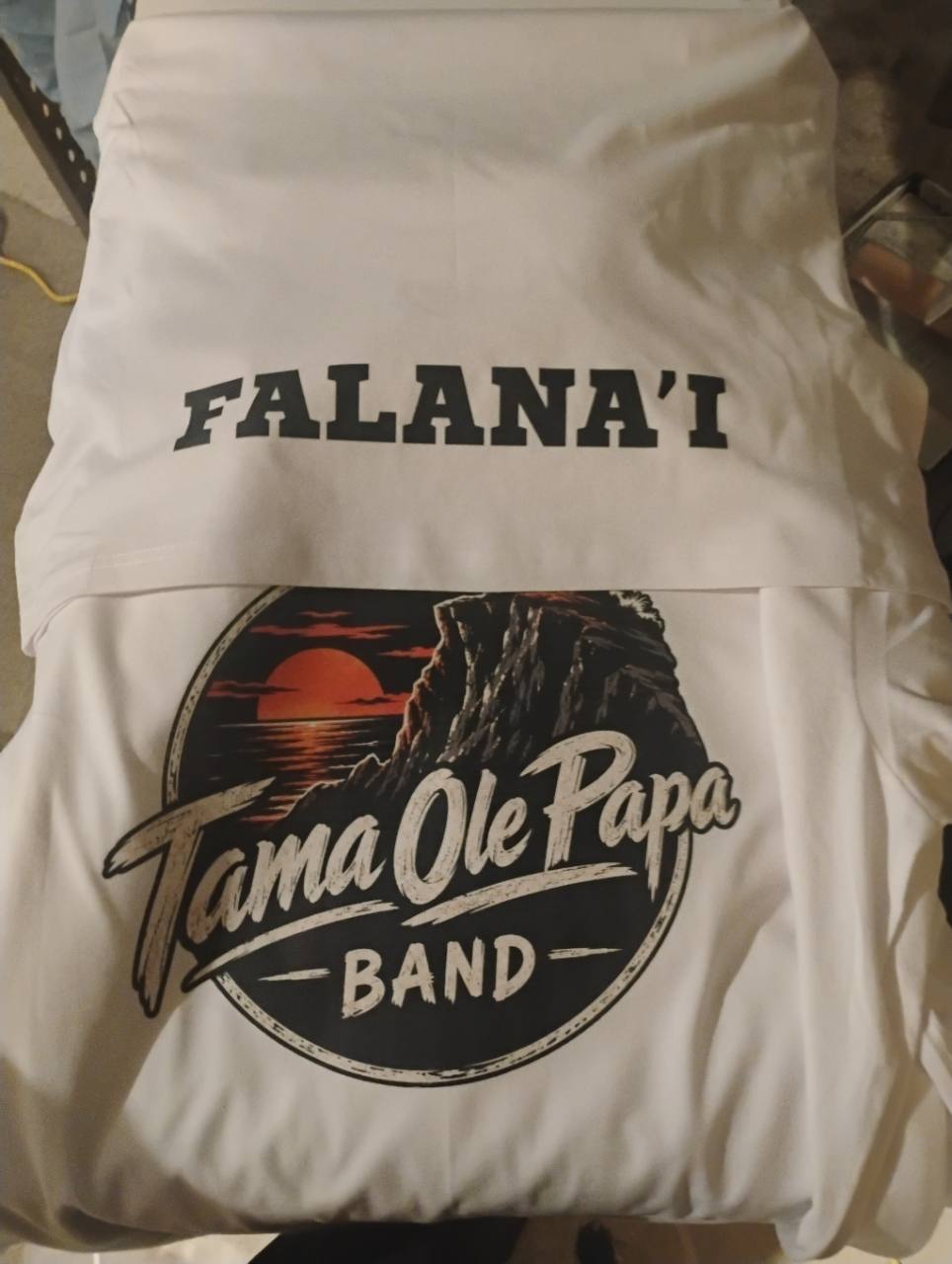 White shirts with a Falana’i name print and a Tama Ole Papa Band graphic.
